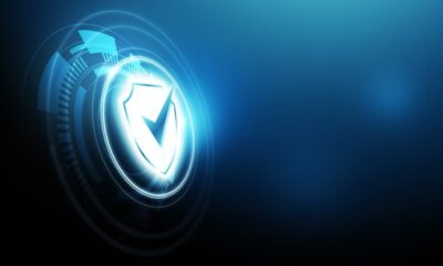Glowing digital shield icon representing cyber security, data protection and secure technology systems on a blue futuristic background. Glowing digital shield icon representing cyber security, data protection and secure technology systems on a blue futuristic background.